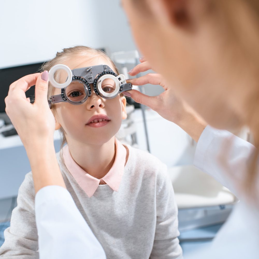 selective-focus-of-ophthalmologist-examining-kid-eyes-with-trial-frame-in-clinic.jpg